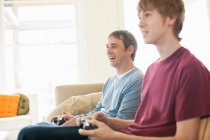 Father and son playing video game in living room — Stock Photo