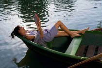 Mujer leyendo un libro en barco - foto de stock