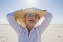 Дівчина в солом'яному капелюсі позує на пляжі — стокове фото