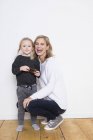 Porträt von Mutter und Tochter, Tochter mit Tannenzapfen — Stockfoto