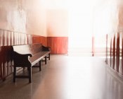 Пустая скамейка в освещенном коридоре — стоковое фото