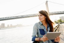 Junge Frau mit digitalem Tablet, manhattan bridge, brooklyn, usa — Stockfoto