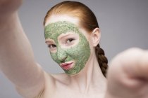 Junge Frau mit Gesichtsmaske, schmollend vor der Kamera — Stockfoto