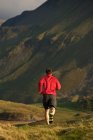 Чоловік біжить по сільській гірській дорозі — стокове фото