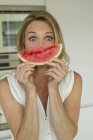 Reife Frau hält Wassermelone in der Hand und schaut in die Kamera — Stockfoto