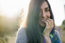 Портрет молодой женщины с длинными каштановыми волосами, улыбающейся — стоковое фото