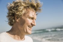 Portrait of man by ocean looking away smiling — Stock Photo