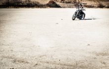 Homem maduro andar de moto na planície árida, Cagliari, Sardenha, Itália — Fotografia de Stock