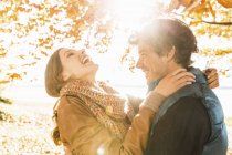 Пара обіймається деревом на сонячному світлі — стокове фото