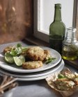 Crab cakes with lime slices on plate — Stock Photo