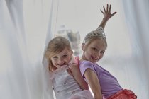 Girls in costume posing beside curtains — Stock Photo