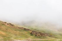 Vista sul paesaggio nebbioso di case in pietra su una collina, stazione sciistica di Oukaimeden, Marrakech, Marocco — Foto stock