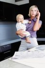 Woman and infant in kitchen — Stock Photo