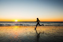 Mujer corriendo en la playa - foto de stock