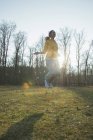 Junge Frau übt auf Feld mit Springseil — Stockfoto