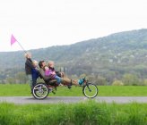 Famille chevauchant ensemble sur vélo à trois roues — Photo de stock