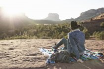 Woman sitting on blanket in desert, looking at view, Sedona, Arizona, USA — Stock Photo