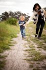 Mutter und kleiner Sohn laufen auf Feldweg — Stockfoto