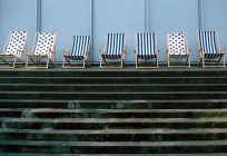 Deckchairs in a row above pool stairs — Stock Photo