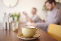 Coppa sul tavolo e le persone in background in un caffè — Foto stock