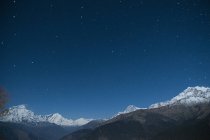 Snowcapped gama de montanhas sob céu estrelado noite, Nepal — Fotografia de Stock