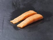 Comida, peixe cru, duas linhas capturados filetes de salmão naturais na ardósia — Fotografia de Stock