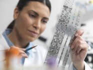 Жіночий учений вивчає ДНК-гель в лабораторії генетичних досліджень — стокове фото