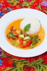 Plate of red curry and rice on colorful tablecloth — Stock Photo