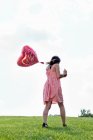 Teenager carrying heart-shaped balloon — Stock Photo