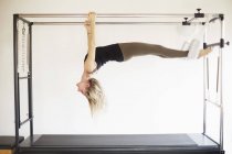 Mature woman practicing pilates on trapeze table in pilates gym — Stock Photo