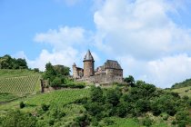 Antico castello su collina verde con cielo azzurro nuvoloso — Foto stock