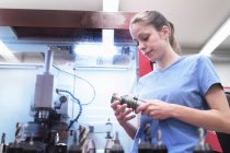 Female engineer checking tool in workshop — Stock Photo