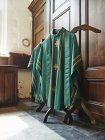 Vestes religiosas verdes penduradas no interior da igreja — Fotografia de Stock