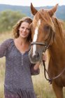 Mulher com um cavalo no prado — Fotografia de Stock