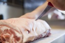 Gros plan des bouchers marquant à la main un joint de viande dans une boucherie — Photo de stock