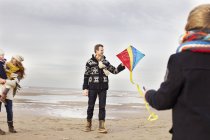 Mitte erwachsene Eltern mit Sohn und Tochter spielen mit Drachen am Strand, bloemendaal aan zee, Niederlande — Stockfoto