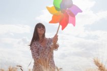 Mujer adulta sosteniendo molino de viento - foto de stock