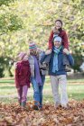 Familie gemeinsam im Park unterwegs, Vater trägt Sohn auf Schultern — Stockfoto