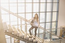 Young woman standing on staircase — Stock Photo