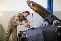 Механік працюють на двигуні автомобіля в гаражі — стокове фото