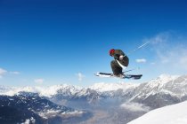 Esquiador saltando de encosta nevada — Fotografia de Stock