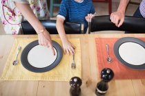 Filho colocando a mesa, mãe apontando — Fotografia de Stock