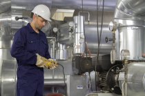 Técnico de monitoramento de fiação de tubos na central elétrica — Fotografia de Stock