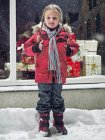 Улыбающаяся девушка, стоящая в снегу, избирательный фокус — стоковое фото