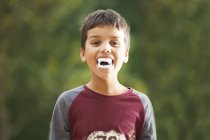 Boy wearing fake vampire teeth with fangs — Stock Photo