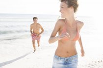 Homem correndo e perseguindo namorada na praia, Maiorca, Espanha — Fotografia de Stock