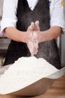 Мужчина-повар растирает муку на руках на коммерческой кухне — стоковое фото