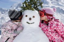 Two girls with snowman — Stock Photo