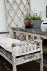 Сельский скамейка и горшок для растений на террасе под дождем — стоковое фото