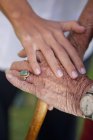 Pflegeassistenten reichen beruhigende Seniorin die Hand — Stockfoto